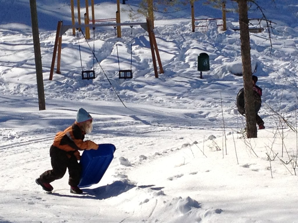 Having fun outside with children years ago. Playing and sliding in the snow and having picnic was so fun!